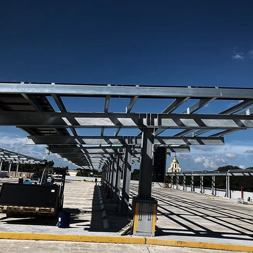 Light-gauge solar carport with overhead panels and vertical support pylons